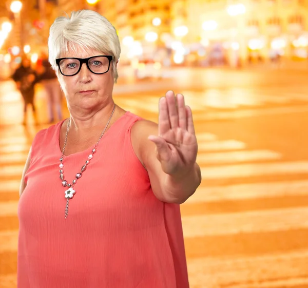 Портрет старшої жінки, що показує знак зупинки — стокове фото