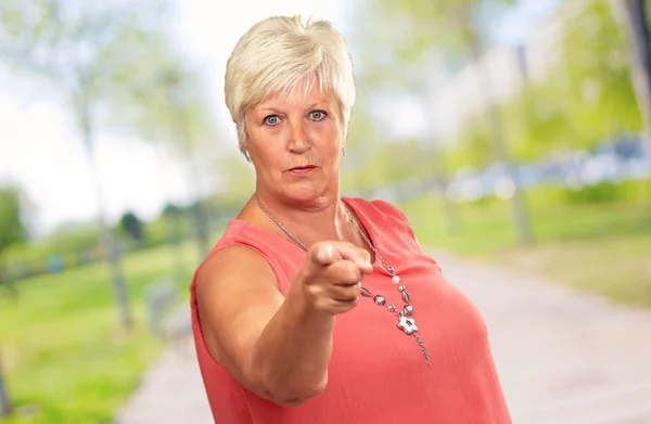 Porträt einer Seniorin, die mit dem Finger zeigt — Stockfoto