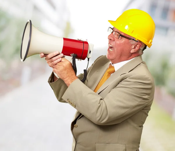 Старший рабочий кричит с мегафоном — стоковое фото