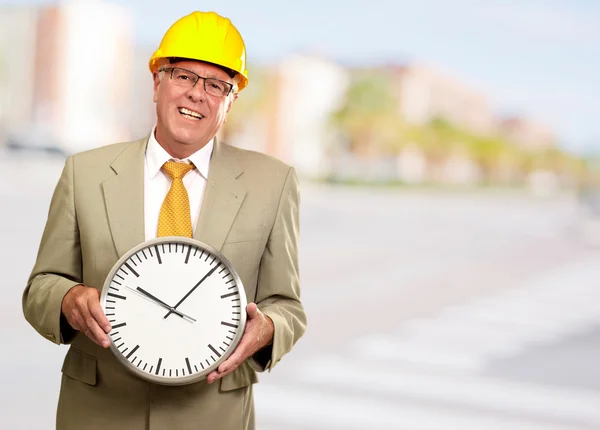 Retrato de un hombre mayor sosteniendo un reloj de pared — Foto de Stock
