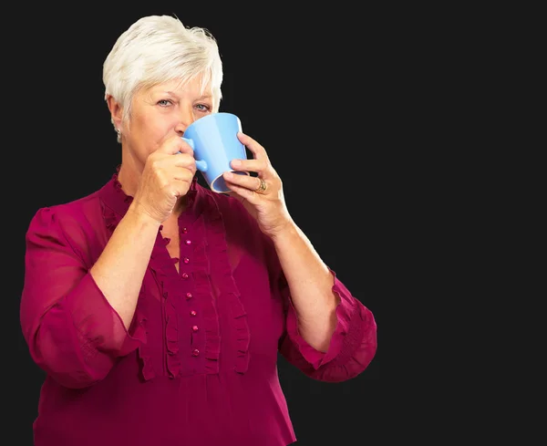 Starší žena pít z poháru — Stock fotografie