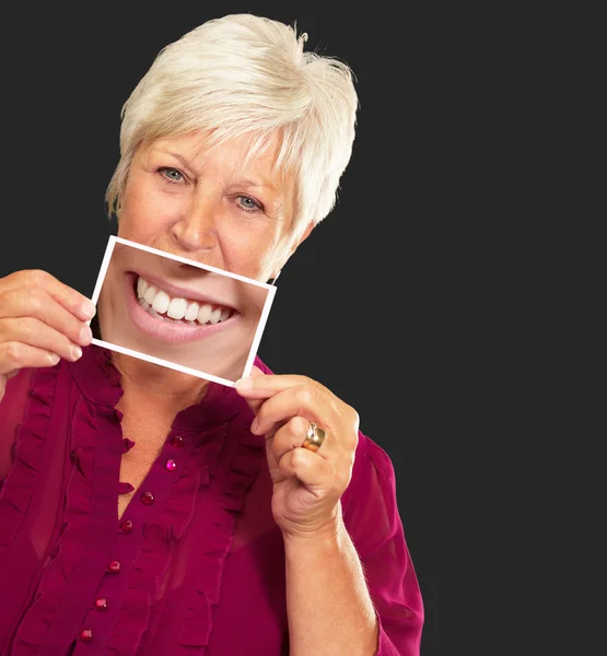 Äldre kvinna med förstoringsglas som visar tänderna — Stockfoto