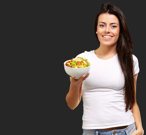 Ung flicka visar en skål med sallad — Stockfoto