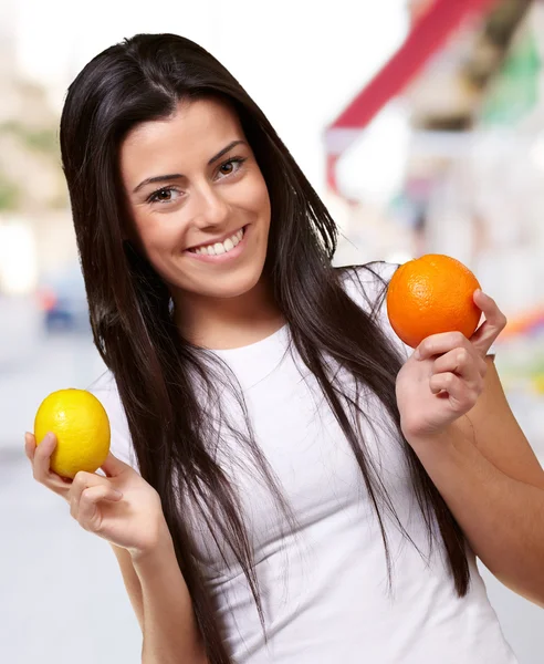 Junges hübsches Mädchen mit Orangen und Zitronen auf der Straße — Stockfoto
