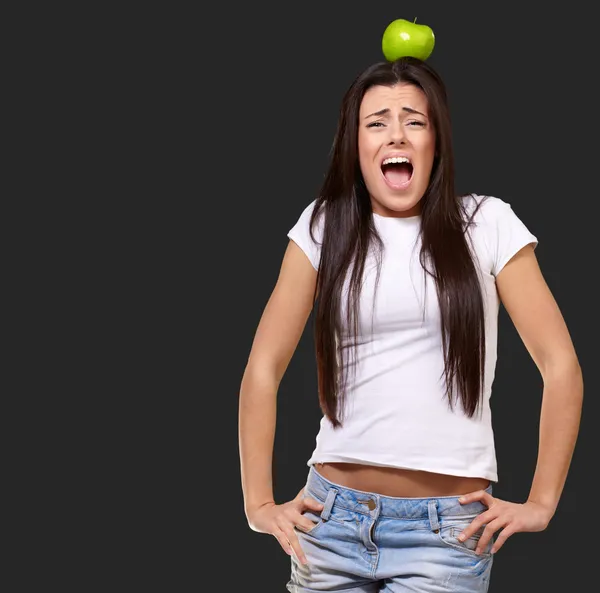 Giovane ragazza con mela in testa — Foto Stock