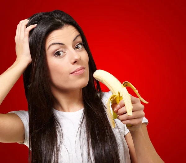 Una joven sosteniendo un plátano — Foto de Stock