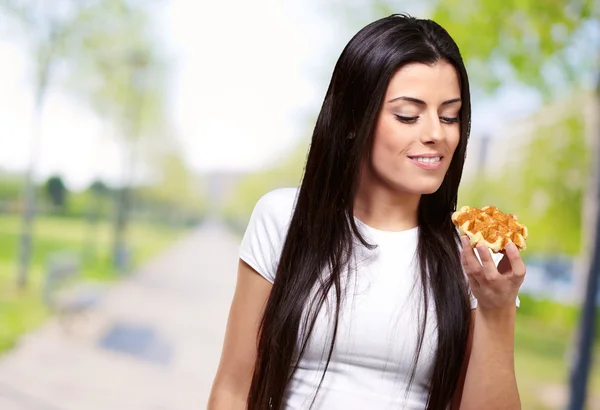 Uma jovem mulher segurando e olhando para Waffle — Fotografia de Stock
