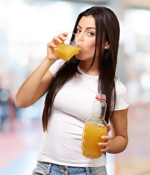 Retrato de menina bebendo suco de laranja interior — Fotografia de Stock