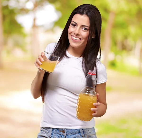 自然 ba に対してオレンジ ジュースを飲む若い女の子の肖像画 — ストック写真