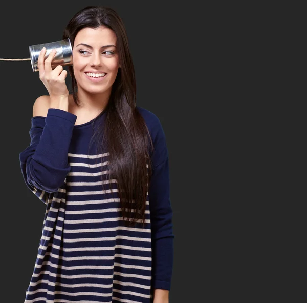 Mujer sosteniendo una lata de metal como un teléfono — Foto de Stock