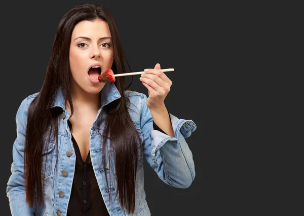 Портрет женщины, поедающей клубнику с шоколадным соусом — стоковое фото