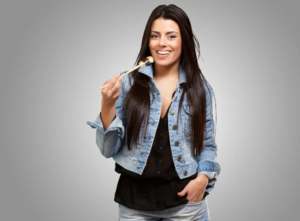 Young Woman Holding A Piece Of Sushi With Chopsticks — Stock Photo, Image