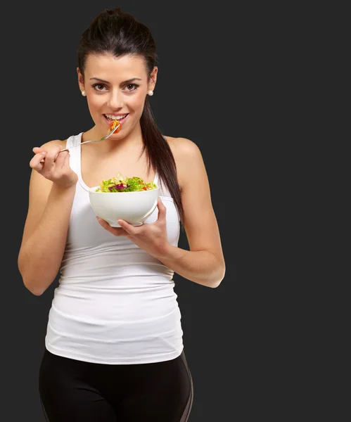 Young woman holding and eating salad — Stock Photo, Image