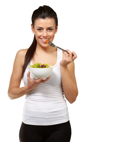 Mujer joven sosteniendo y comiendo ensalada — Foto de Stock