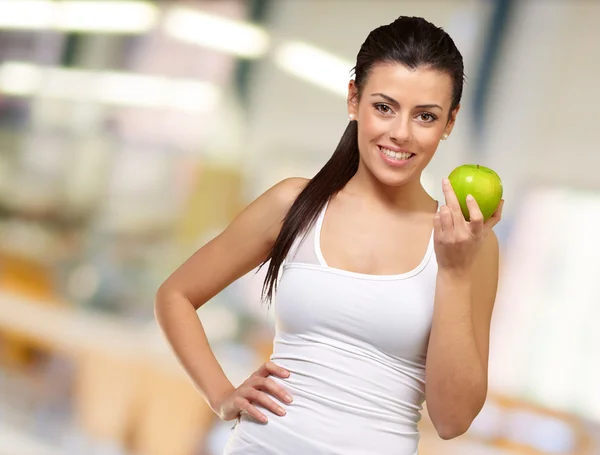Mladá žena drží jablko — Stock fotografie