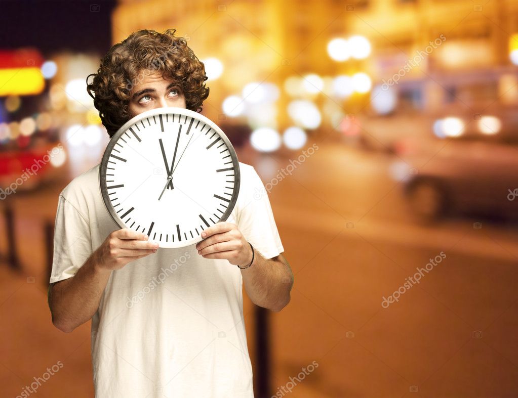 Man hiding behind clock