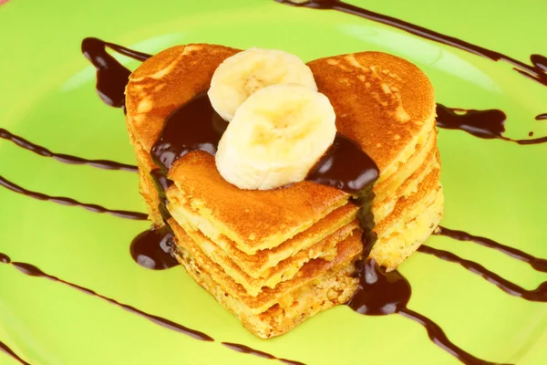 Stack of heart shaped pancakes with chocolate and banana — Stock Photo, Image