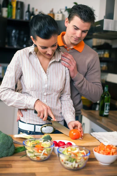 Νεαρό ζευγάρι στην κουζίνα προετοιμασία του γεύματος — Φωτογραφία Αρχείου
