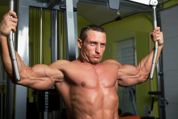 Ejercicio de hombre en forma de músculo en gimnasio deportivo club de fitness —  Fotos de Stock