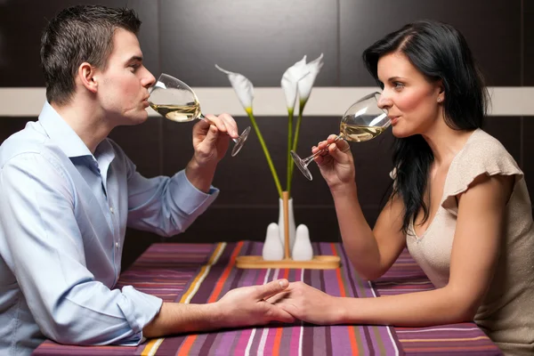 Junges Paar trinkt Wein und flirtet Stockbild