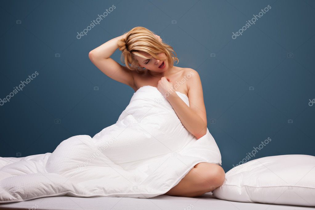 Young attractive woman yawning in bed