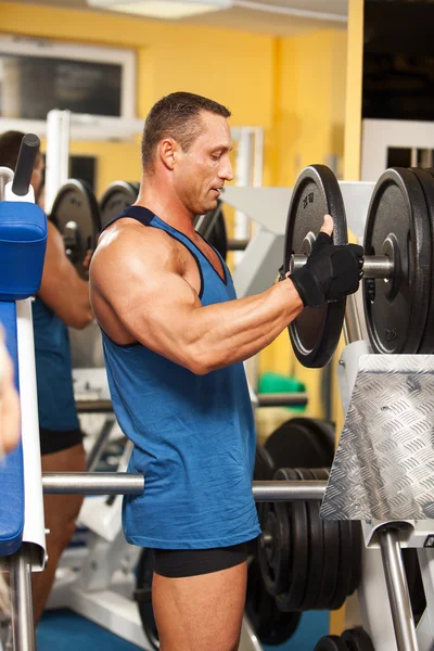 Strong man preparing his training machine — Stock Photo, Image