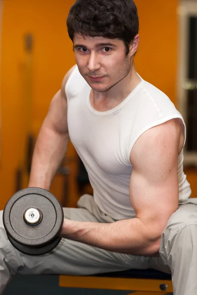 Młody człowiek podnoszenia siłowni fitness dumbell — Zdjęcie stockowe