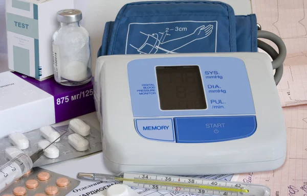 Monómetro, seringa, termómetro, electrocardiograma e material médico — Fotografia de Stock