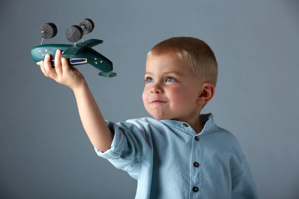 Мальчик с деревянным самолетом — стоковое фото