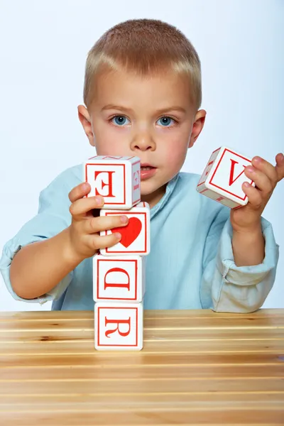 Мальчик играет с алфавитными блоками — стоковое фото