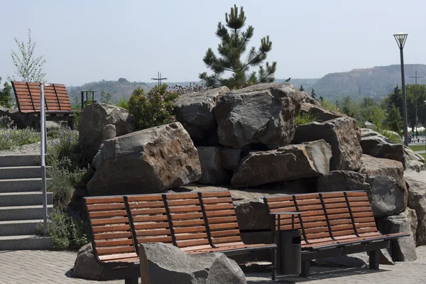 Пустые скамейки в саду из камней — стоковое фото