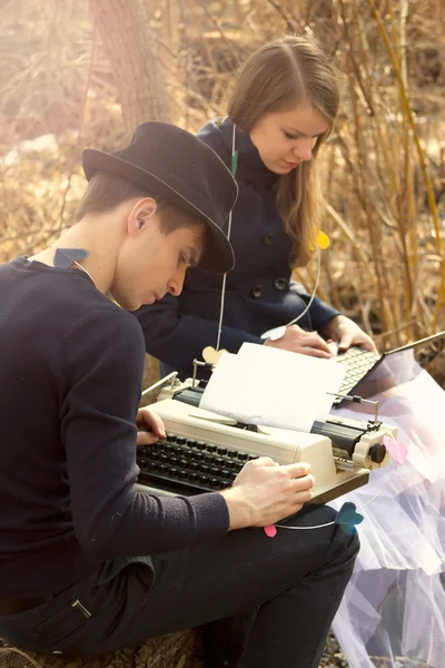 Casal jovem freelance digitação na máquina de escrever — Fotografia de Stock