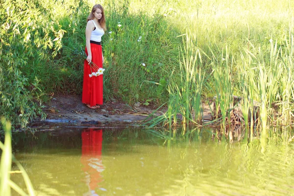 美丽的女孩在一条长红裙子 — 图库照片