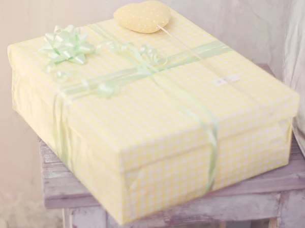 Gift packed in a yellow box a rustic style — Stock Photo, Image