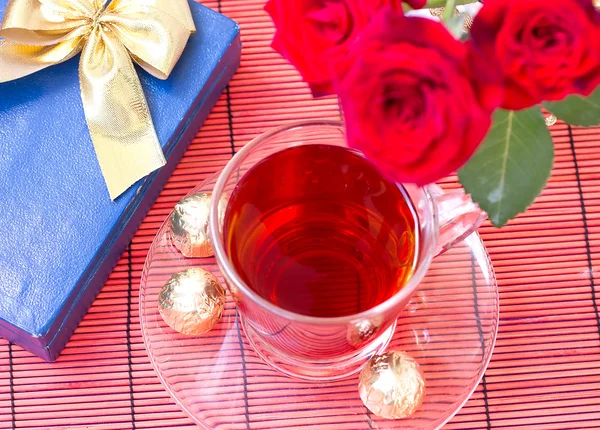 Tea with sweets and blue box, a bouquet of roses — Stock Photo, Image