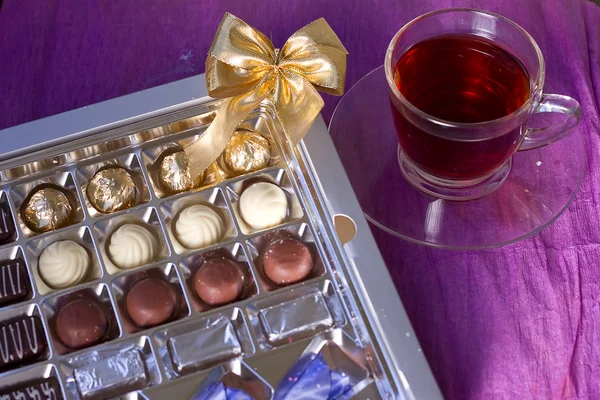 Holiday box of chocolates next cup of tea — Stock Photo, Image