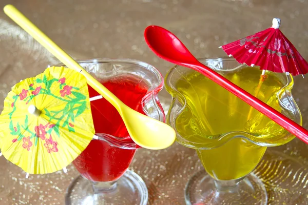 Glasses with red and yellow jelly with long spoons — Stock Photo, Image