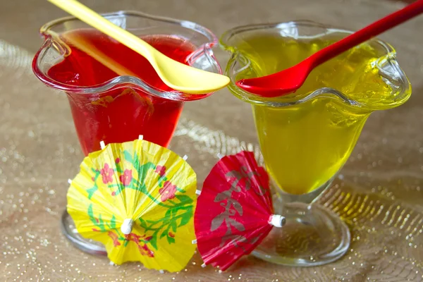 Glasses with yellow and red jelly with long spoons — Stock Photo, Image
