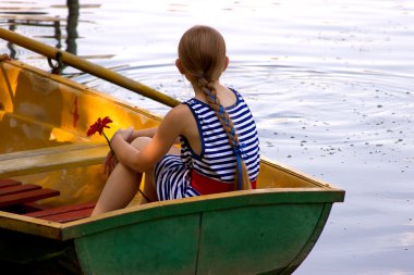 A girl with hair in a braid sits in a boat clipart