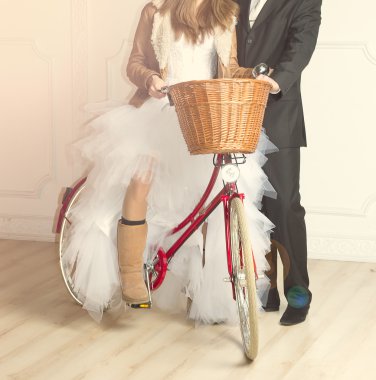 Groom and bride in wedding beside old bicycle clipart