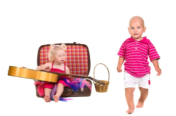 Boy and girl playing near a suitcase, a guitar — Stock Photo, Image