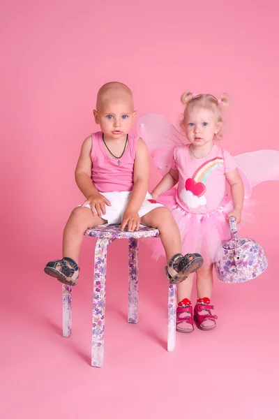 Jongen en meisje op een roze achtergrond — Stockfoto