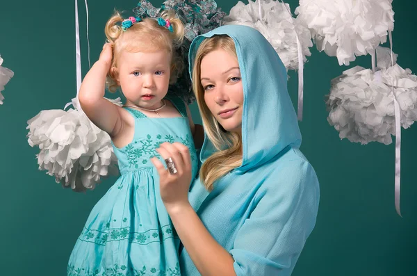 Portrait of mother and daughter on a turquoise background — Stock Photo, Image