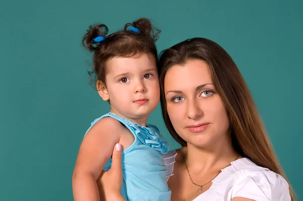 Portret van moeder en dochter op een turkooizen achtergrond — Stockfoto