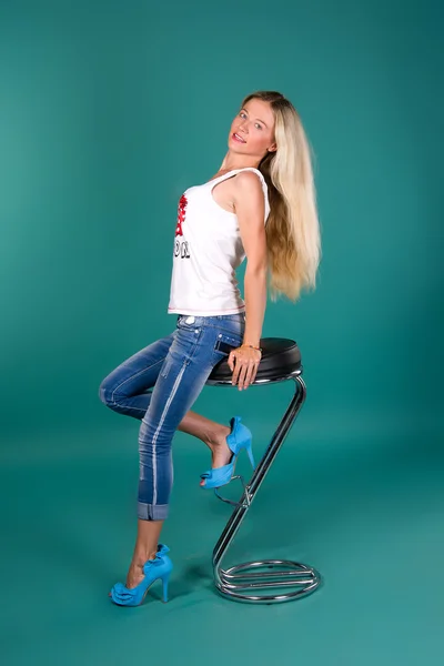 Sexy blondýnka sedí na barovou stoličku — Stock fotografie