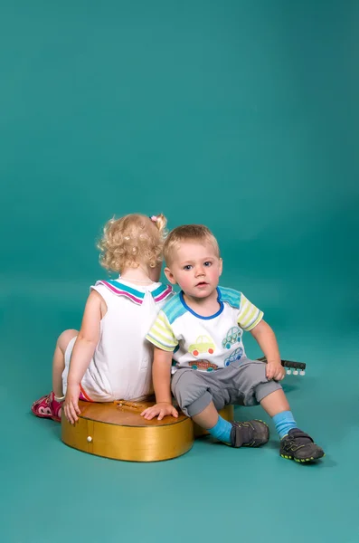 Dívka a chlapec sedí na kytaru zády k sobě — Stock fotografie