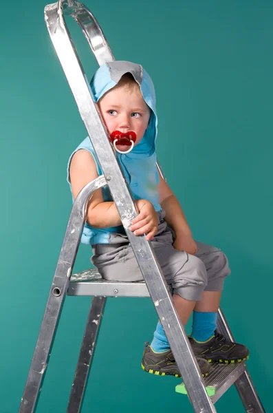 Rapaz senta-se numa escada, no capô — Fotografia de Stock