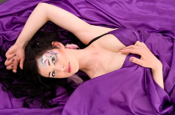 Meisje met professionele make-up is op zijde stof — Stockfoto