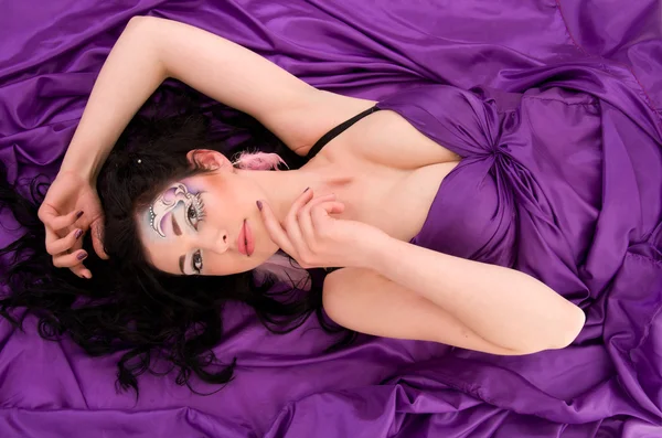 Menina com maquiagem profissional está em tecido de seda — Fotografia de Stock