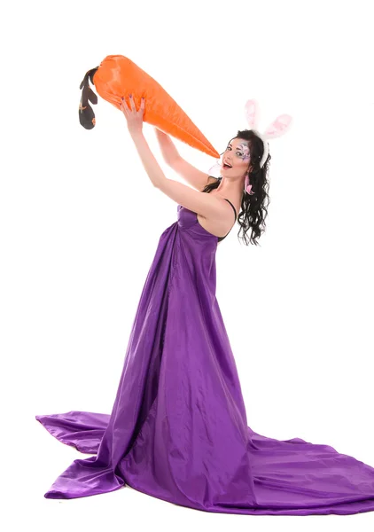 Dívka v hedvábných šatech, s králičíma ušima a mrkev v ruce — Stock fotografie